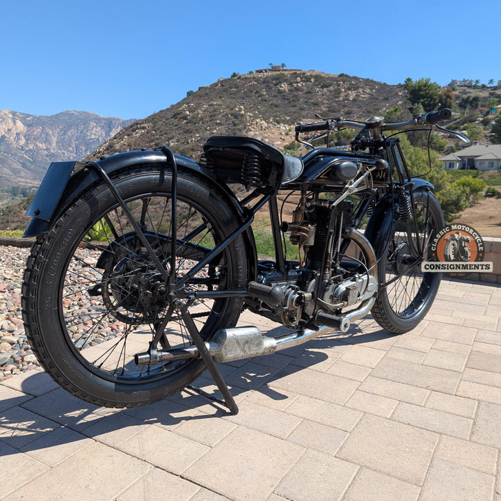 Vintage motorcycle on a paved surface with a mountainous landscape in the background