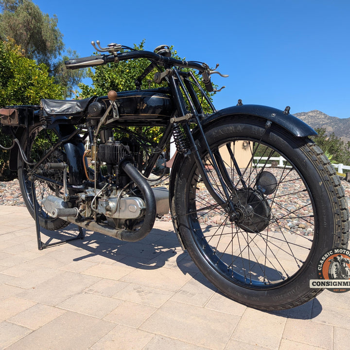 Vintage motorcycle on a paved surface with a scenic background