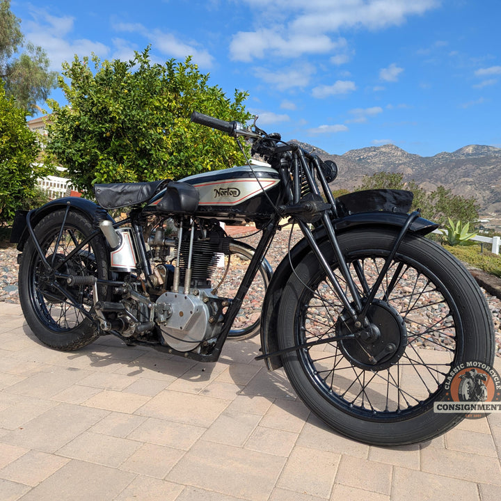 Vintage motorcycle on a paved area with a scenic background